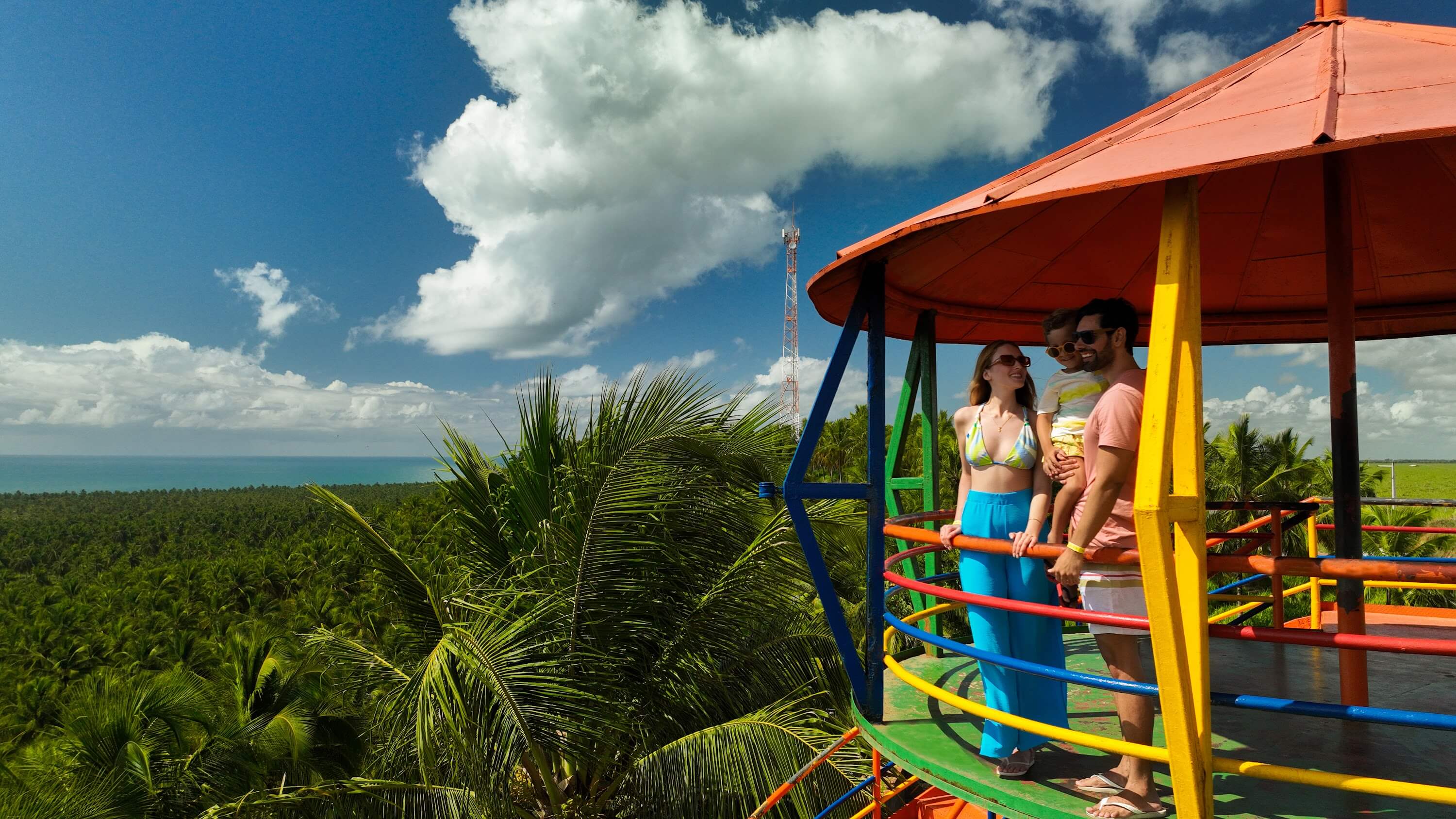 Família vê a praia do Gunga no Mirante de Maragogi, com vista pra vasta vegetação de coqueiros e pro mar.